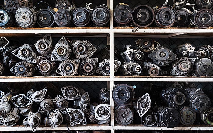 Old car alternators and starters on mechanic's shelf